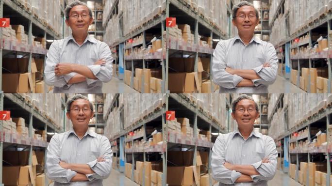 商业高级男子企业家肖像站在仓库里，双臂对着镜头微笑。智能仓库管理系统。仓库，技术，人，创新，领导力，