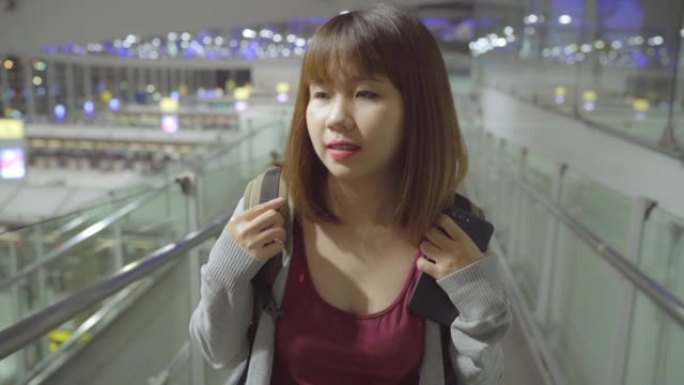 慢动作-年轻的亚洲背包客妇女在国际机场登机口登机时走在航站楼大厅。生活方式背包旅游度假概念。