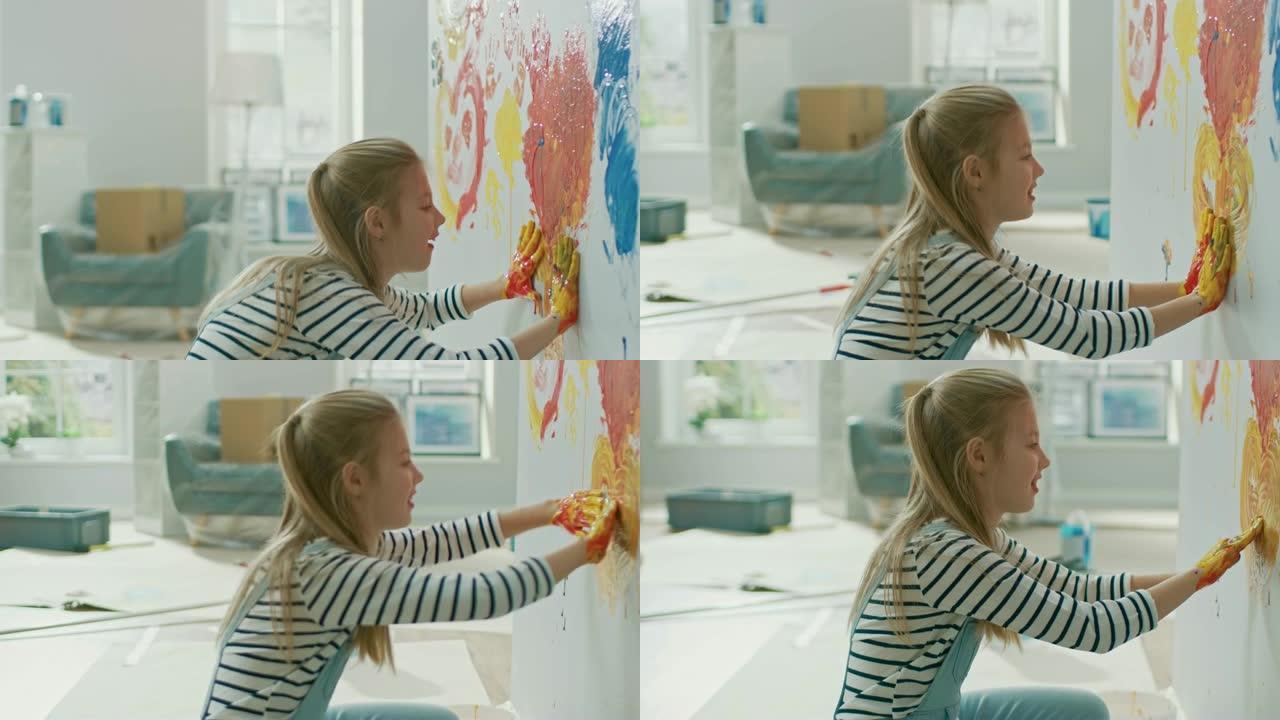 快乐的小女孩用手蘸上五颜六色的颜料在墙上画了一颗生动的心。她玩得很开心，笑得很开心。家正在装修。