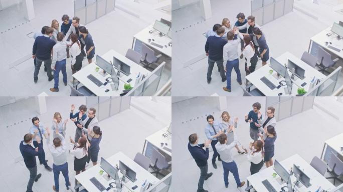 办公室工作人员以创造力和共同事业的统一精神进行团队建设练习。八个成功人士一起为新的开始鼓掌。现代明亮