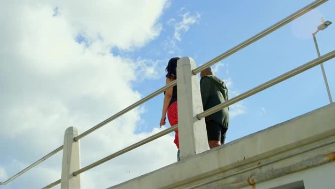 情侣在4k栏杆附近行走时相互作用的低角度视图