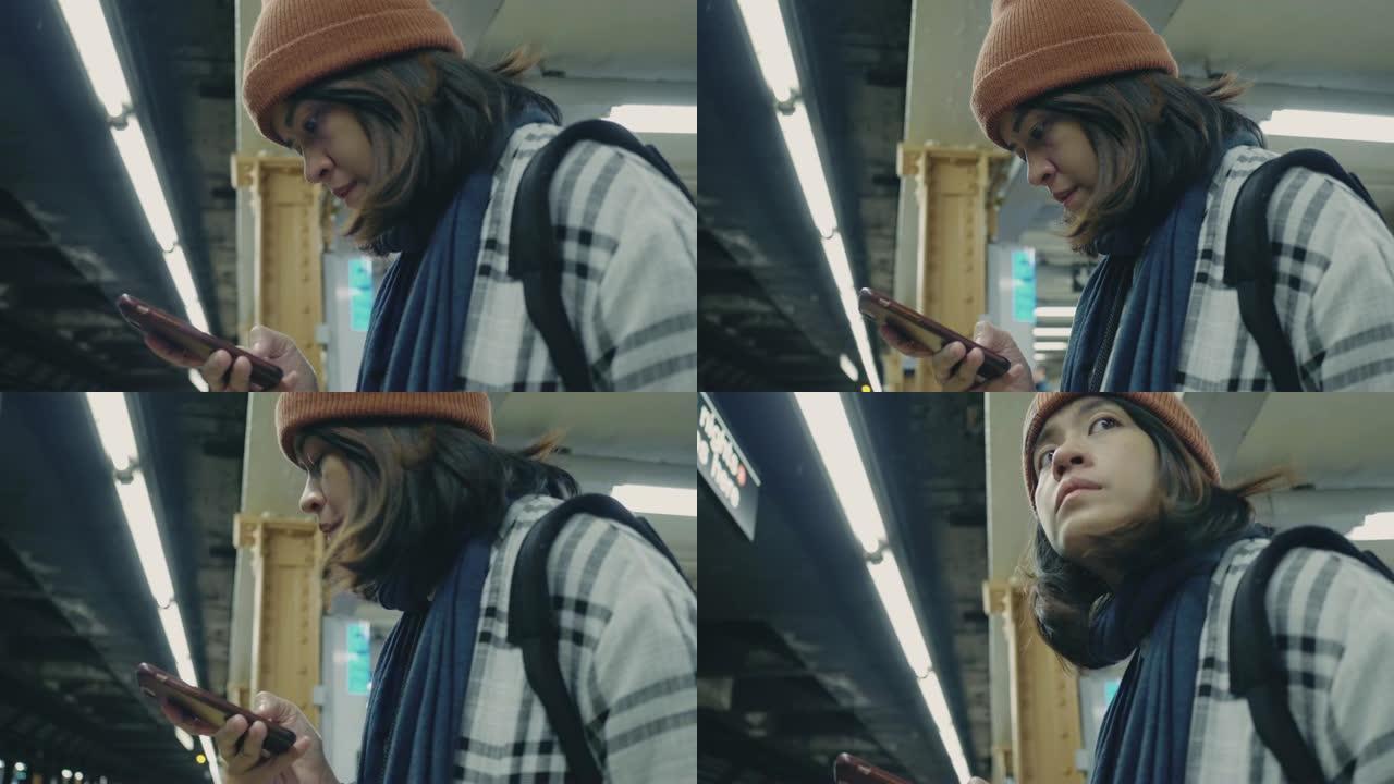 在地铁平台上使用智能手机的旅游妇女
