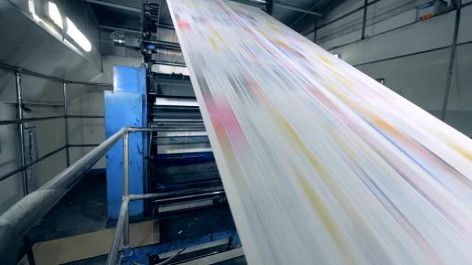 长纸在印刷办公室的一条线上移动，工厂设备在工作。