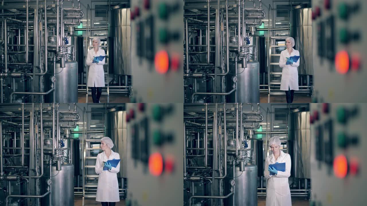 一名妇女走进工厂，检查机器。