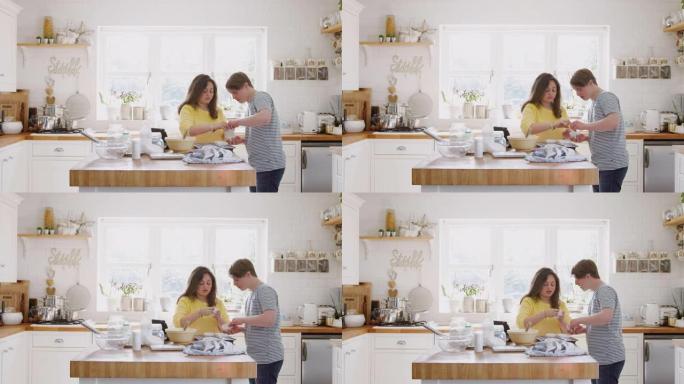 年轻的唐斯综合症夫妇将纸杯蛋糕盒放入家里厨房的托盘中