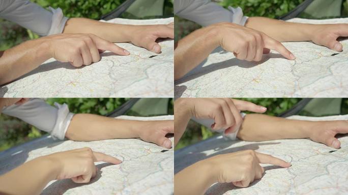 慢动作: 无法识别的年轻男女计划在地图上的旅程路线