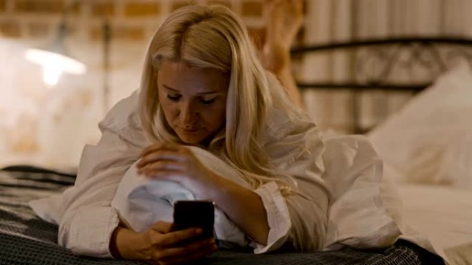 女士躺在床上时使用智能手机