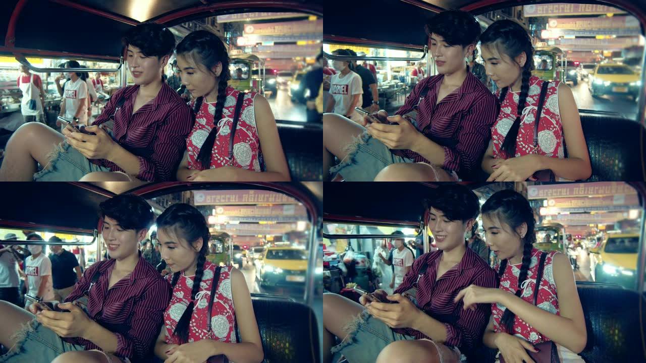 幸福的年轻夫妇在曼谷市的嘟嘟车上自拍。