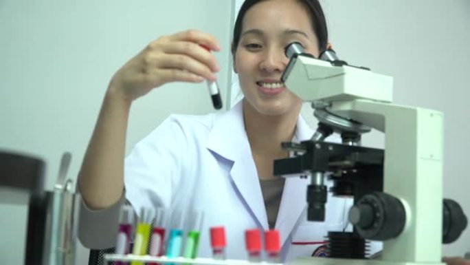 女研究科学家在实验室中使用微量移液管填充试管