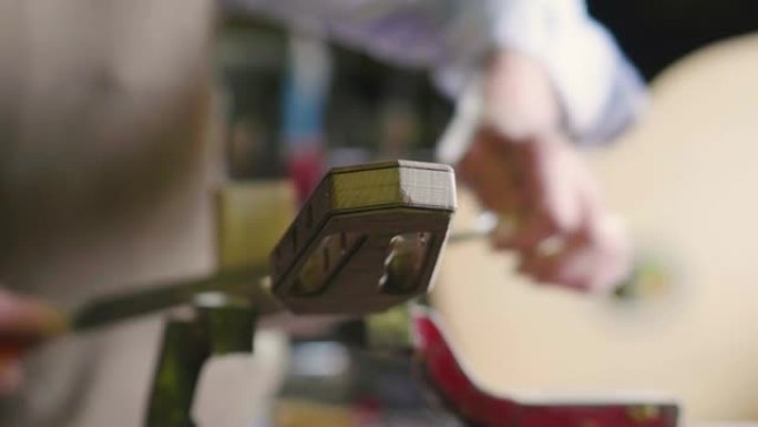 在他的实验室里，一位liutist为音乐家制作高质量的吉他，用优质的木材加工。