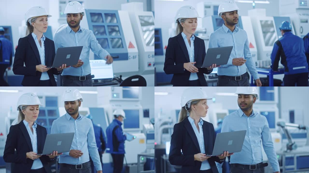 总工程师和项目经理穿着安全背心和安全帽，在现代工厂使用笔记本电脑，交谈，优化生产线。工业设施: 从事