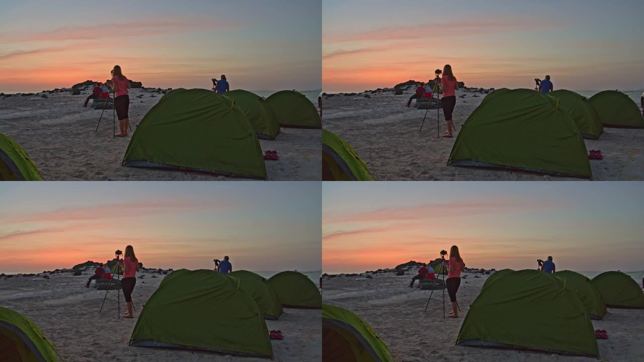 DS游客在日落时在海滩上拍照