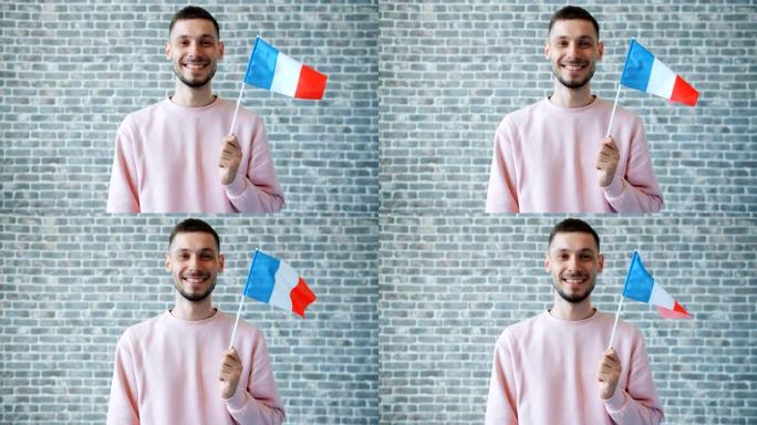 砖墙背景上带有法国国旗的快乐年轻人肖像