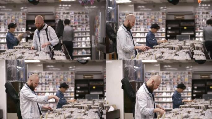高加索音乐家，吉他在唱片店浏览黑胶唱片