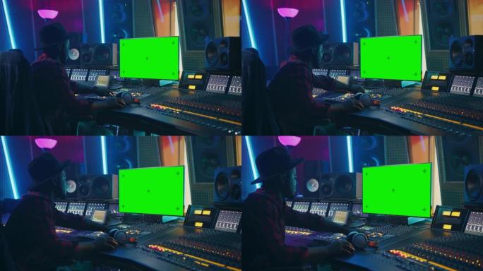 在音乐唱片工作室工作的时尚音频制作人，使用绿屏色度键电脑显示器、混音器板均衡器和控制台来创作新的热门