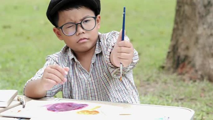 小快乐男孩在公园画画