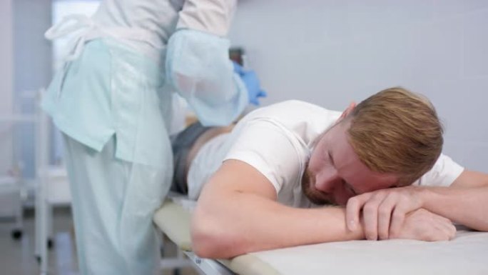 男子躺在医疗沙发上，接受臀部注射
