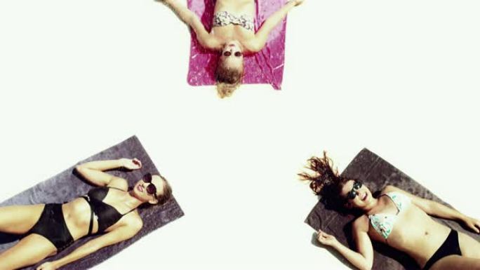 三个模特女人正在晒日光浴