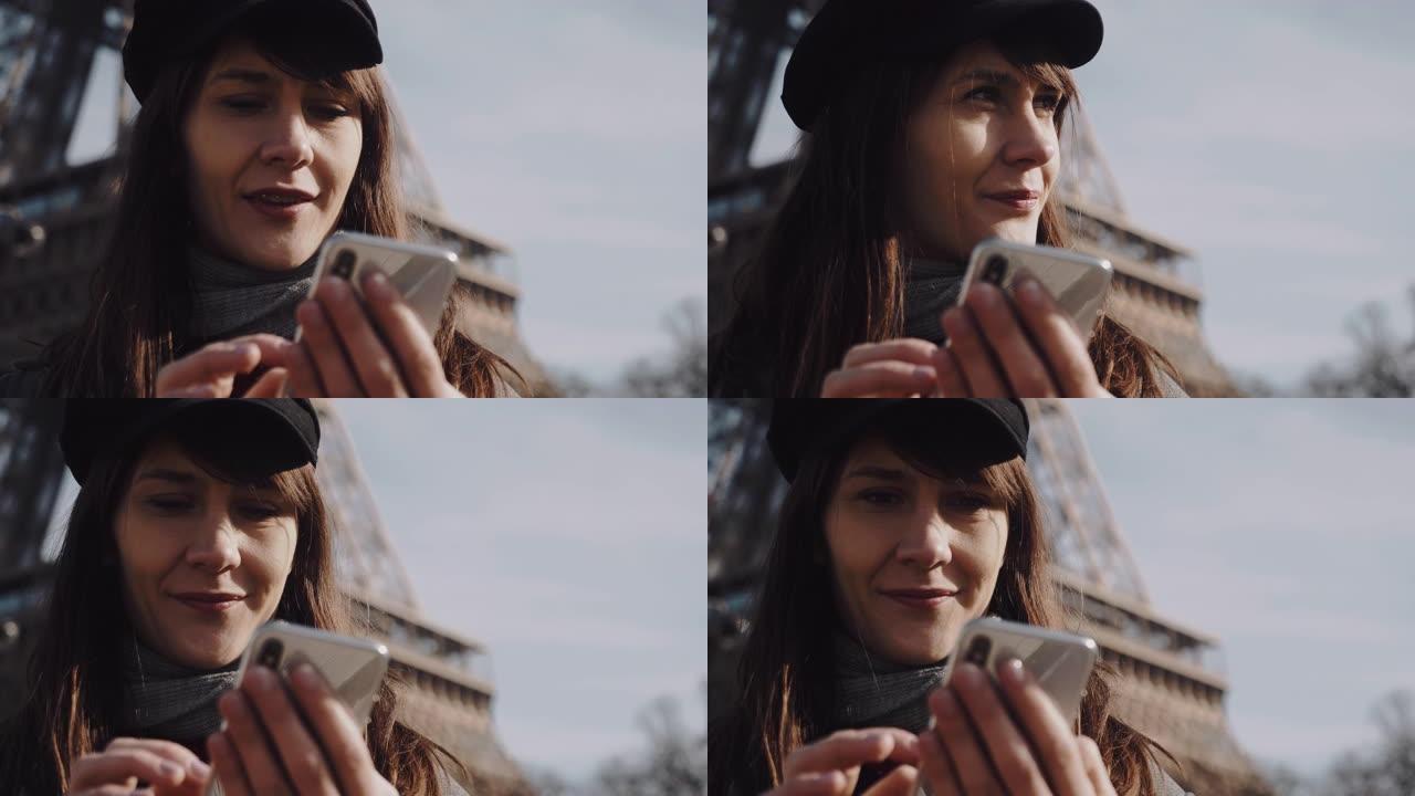 美丽的年轻女商人使用智能手机购物应用程序的肖像，在阳光明媚的巴黎埃菲尔铁塔慢动作中微笑
