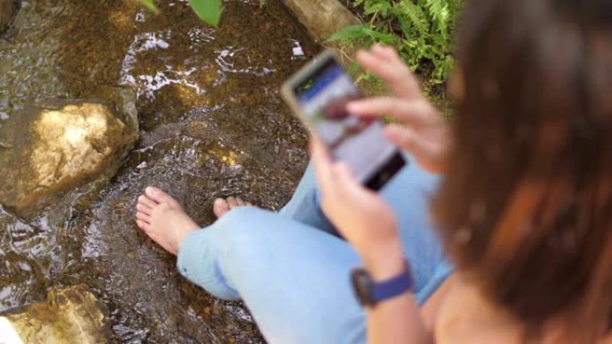 女人的脚浸泡在溪流瀑布中放松