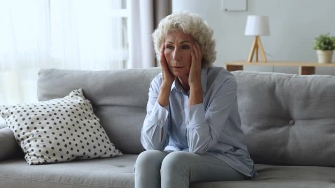 强调担心的老年妇女担心家里的健康问题
