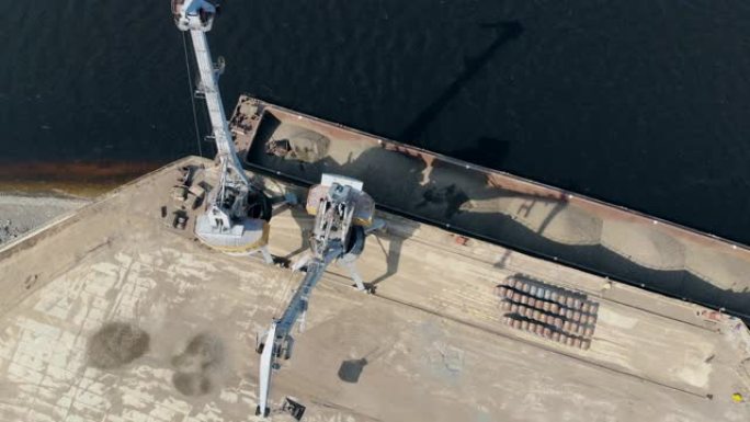 高起重机在码头用碎石工作，卸下驳船。