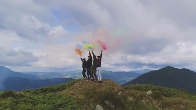 四名群众带着彩色烟雾弹站在山上
