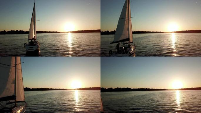 缓缓漂浮在湖上的帆船鸟瞰图。日落