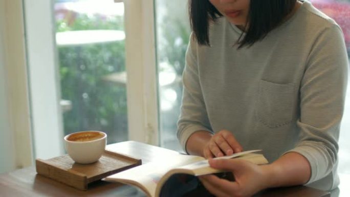女人看书，在咖啡馆喝咖啡