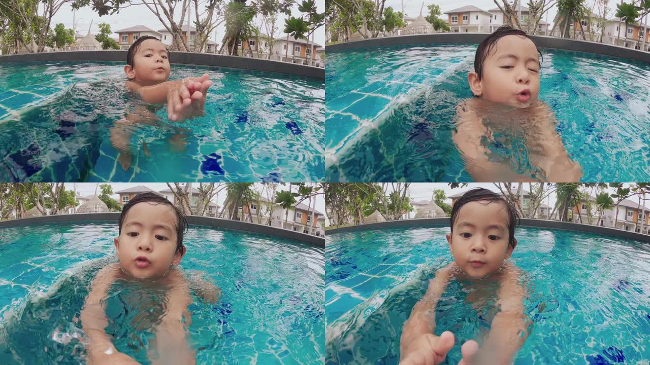 小男孩正在游泳池游泳和玩耍