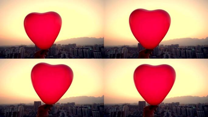 手持红色气球城市背景爱心气球温馨