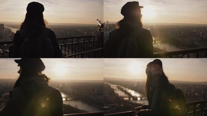 镜头跟随年轻快乐微笑的旅游女人在埃菲尔铁塔慢动作上观看巴黎日落全景。