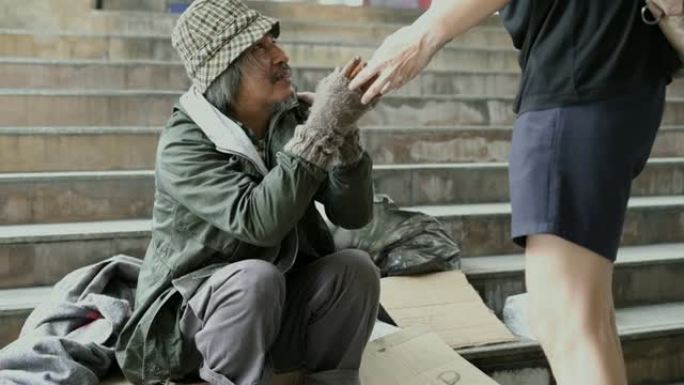人们在人行道上给无家可归的人食物。