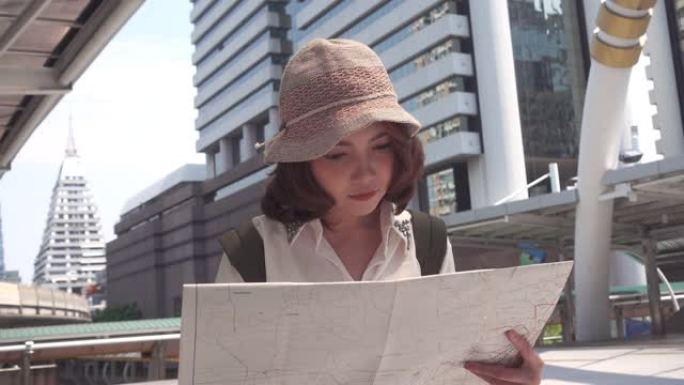 慢动作-快乐美丽的年轻亚洲背包客女人在泰国曼谷旅行时的方向和位置地图上的寻找。生活方式背包旅游度假概
