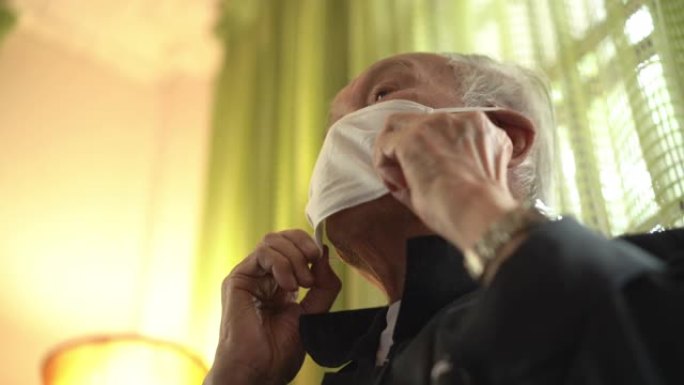 低角度观泰国老人戴口罩在家咳嗽