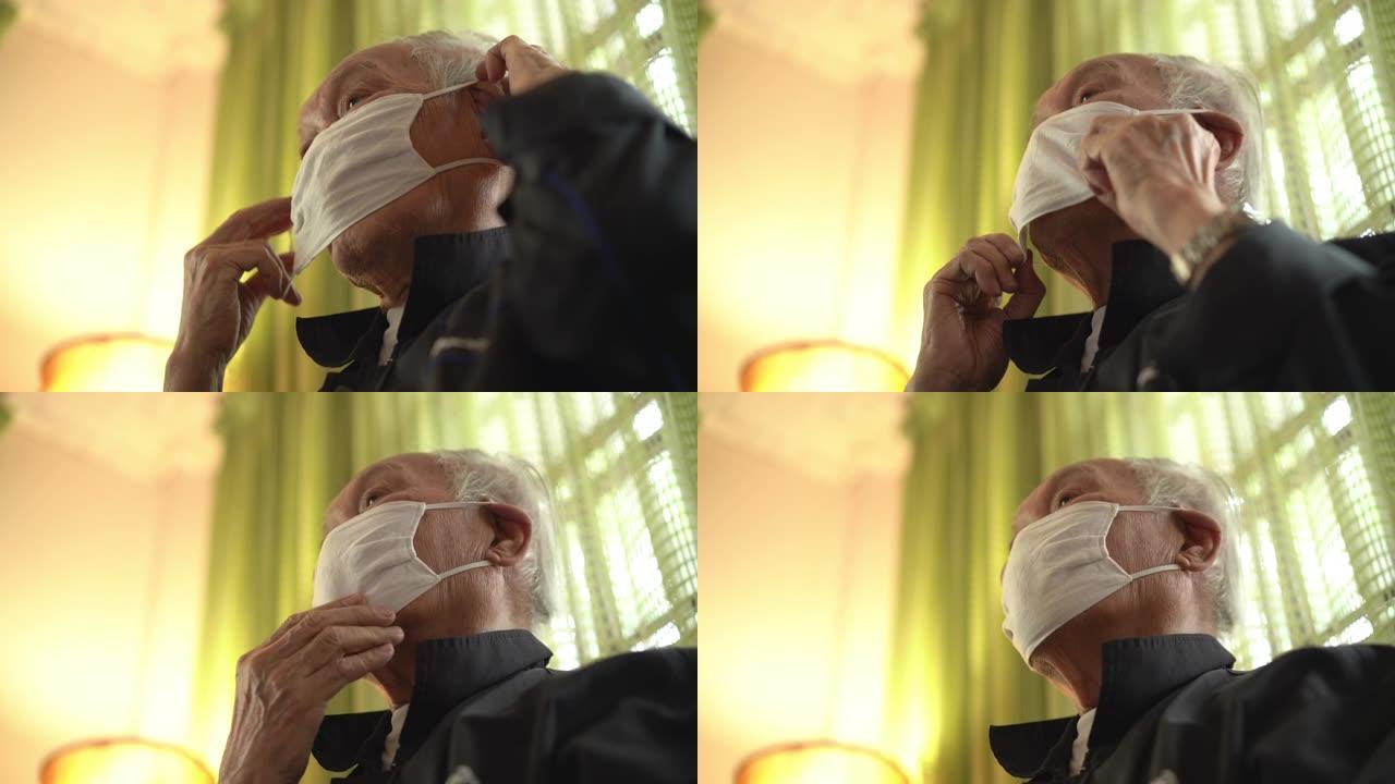 低角度观泰国老人戴口罩在家咳嗽
