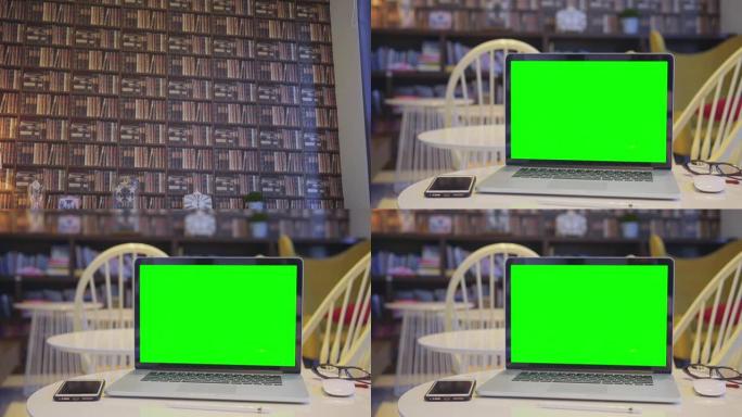 在图书馆中倾斜带有绿色屏幕的计算机笔记本电脑，没有人