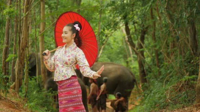 在自然背景中跳舞的传统东南亚服装中迷人的亚洲女人的肖像。