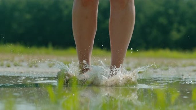 一个女人的SLO MO腿在泥泞的水坑中大放异彩