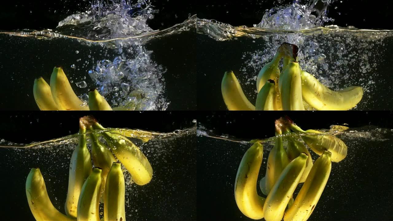 香蕉掉进水里。黑色背景。慢动作。