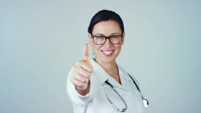 一位穿着白色外套和听诊器的女医生的肖像在白色背景上微笑着看着相机。