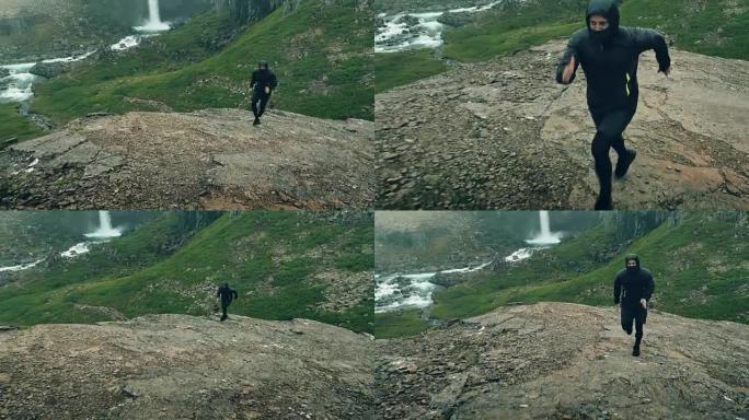 山地慢跑。沿着山路跑的人。背景中的瀑布