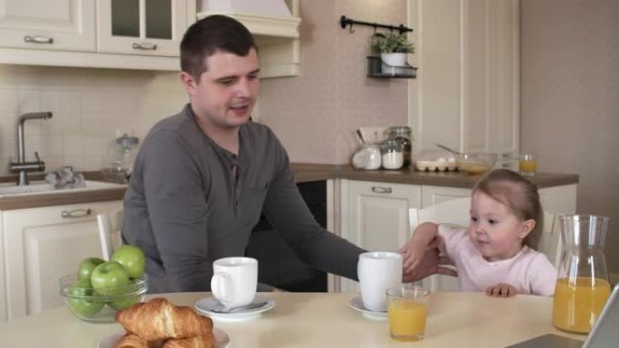 有仿生肢体的高加索爸爸和女儿一起吃早餐