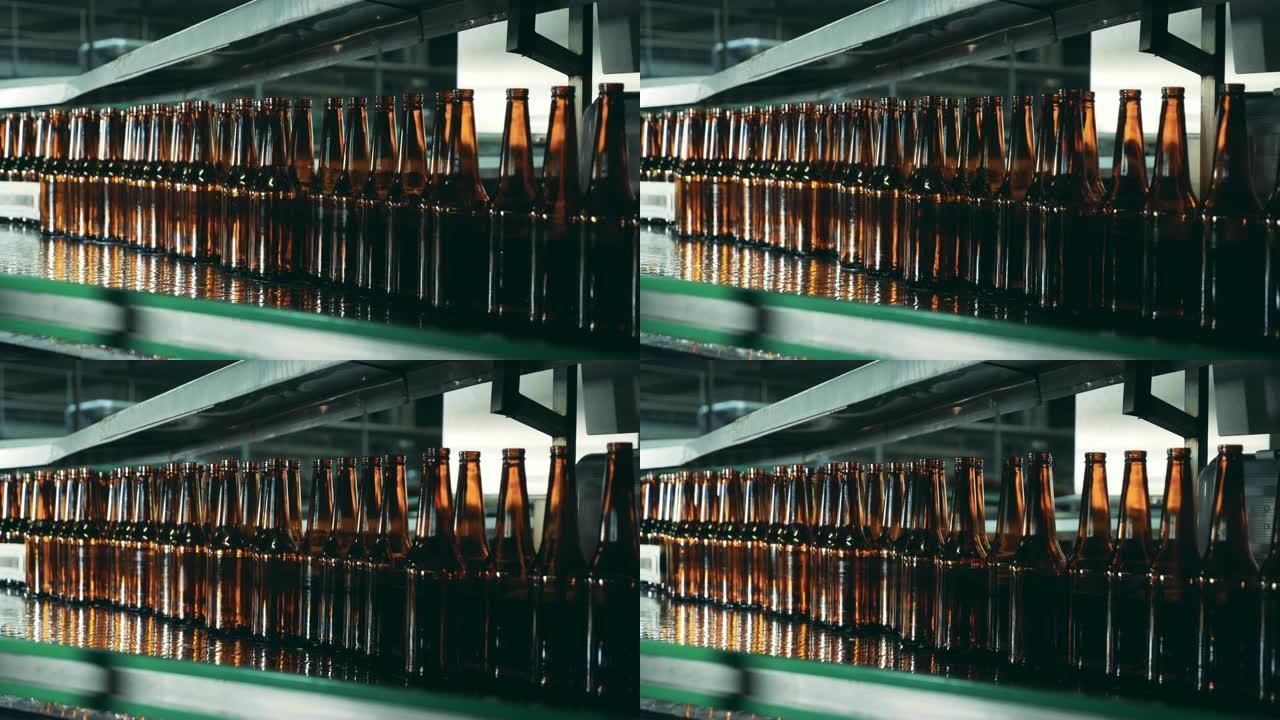 啤酒厂传送带上的玻璃瓶，特写。