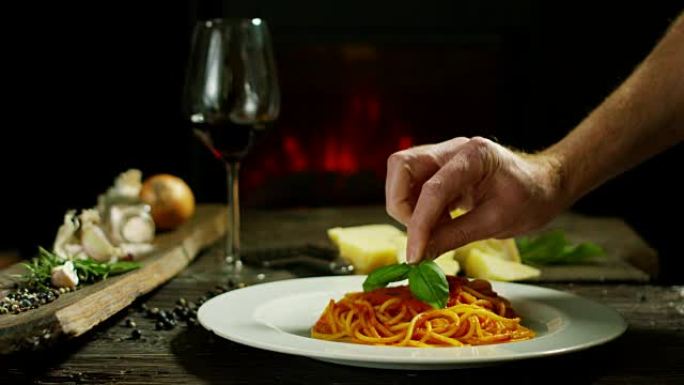 美丽的意大利面食在古老的传统小屋与壁炉和放松的气氛与主厨装饰盘帕尔马干酪和罗勒叶