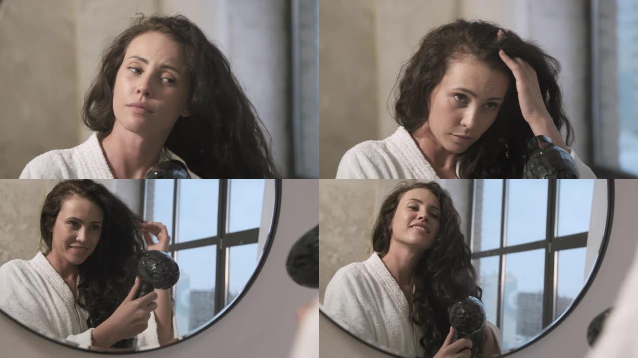 穿着浴袍的女人在镜子前晒头发