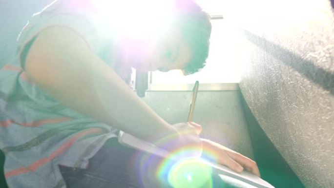 年轻的男生在校车上做家庭作业