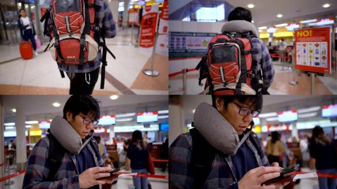 背包客拿着智能手机走到机场的登机柜台
