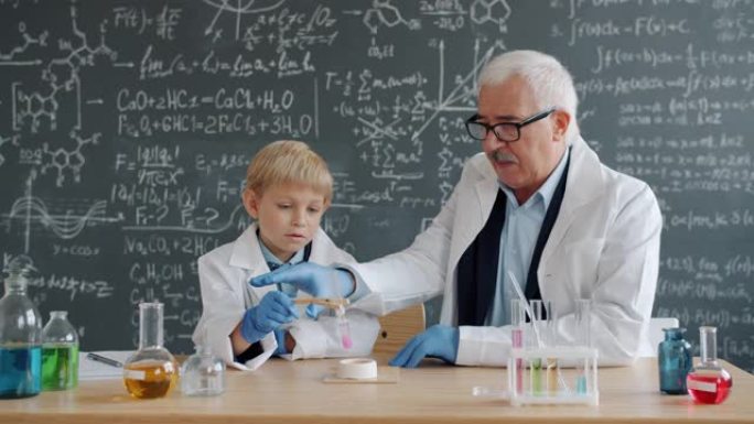化学教授和小孩在学校实验室做化学测试