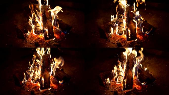 夜晚黑暗中的火焰。篝火燃烧的木头。余烬是高温红色。慢动作特写镜头